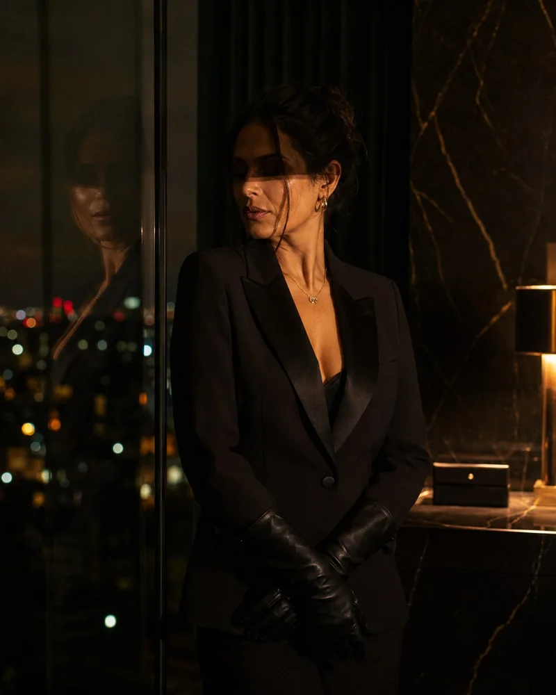 Mulher de luvas diante de um vidro refletivo, preservando sua identidade